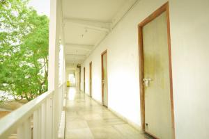 an empty corridor of a white building with a door at Balaji Lodge in Villupuram