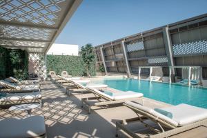 a swimming pool with chaise lounge chairs and a resort at Steigenberger Hotel Doha in Doha