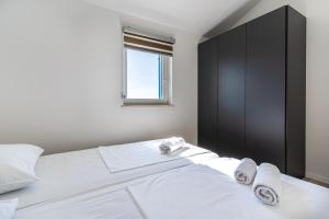 a bedroom with a large white bed with towels on it at Breakaway Apartment in Cres