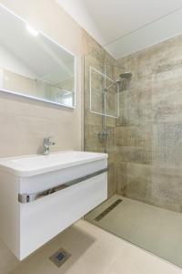 a bathroom with a white sink and a mirror at Breakaway Apartment in Cres +16 photos