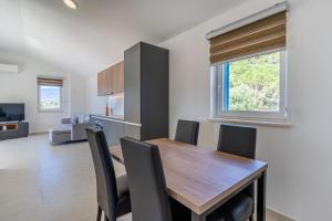 a kitchen and dining room with a wooden table and chairs at Breakaway Apartment in Cres