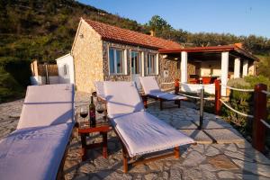 a patio with two chairs and a table and a house at Holiday Home Baki in Bol