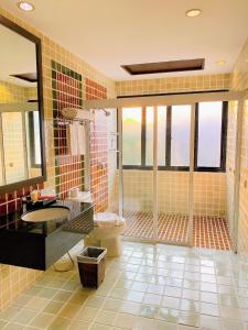 uma casa de banho com um chuveiro, um lavatório e um WC. em The Empire Nimman em Chiang Mai