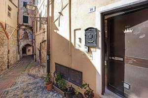 um beco com uma porta e plantas do lado de um edifício em Domus Regina Elena em Sanremo