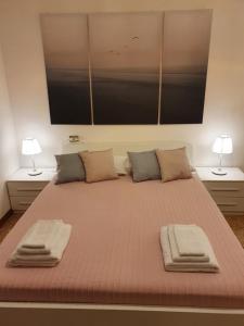 Cette chambre comprend un grand lit et 2 lampes. dans l'établissement 12 minuti da Venezia appartamento con parcheggio, à Marghera