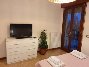 una camera da letto con TV sopra un comò di 12 minuti da Venezia appartamento con parcheggio a Marghera