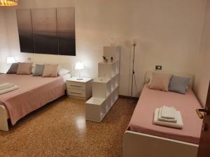 um quarto com 2 camas e uma mesa de cabeceira com um candeeiro em 12 minuti da Venezia appartamento con parcheggio em Marghera