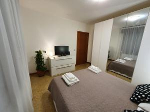 a small room with a bed and a television at 12 minuti da Venezia appartamento con parcheggio in Marghera
