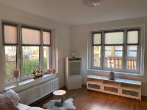 a living room with three windows and a table at Apartmán Na Polabí in Mělník