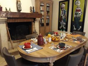 une table à manger avec des chaises et une cheminée dans l'établissement Au Pichet, à Saint-Orens
