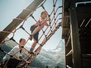 two children are riding on a roller coaster at Riffelalp Resort 2222m in Zermatt
