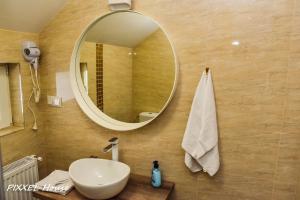 a bathroom with a sink and a mirror on a wall at Pixxel House in Moieciu de Sus