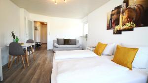 una sala de estar con dos camas y una mesa en Geräumige Wohnung mit Balkon - Zentral - Kostenloses Parken, en Würzburg 17 fotos más
