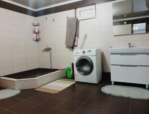 a bathroom with a washing machine and a bath tub at БЕЛЫЙ ДОМ in Gudauta