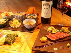 una mesa con una botella de vino y algo de comida en Shirakaba, en Nozawa Onsen