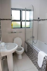 y baño con aseo, lavabo y ducha. en River View Villa Self Catering, en Francistown