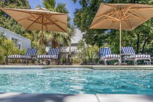 a group of chairs and umbrellas next to a pool at Petit Ermitage in Franschhoek