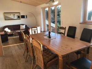 a dining room with a wooden table and chairs at Ferienwohnung NaturZeit in Sankt Englmar