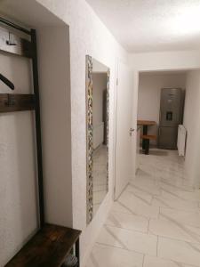 a hallway with white walls and a mirror on the wall at Schöne Einliegerwohnung in Hechingen in Hechingen +15 photos