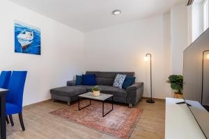 a living room with a couch and a table at Apartment Blue Monstéra in Cres