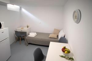 Camera piccola con letto e tavolo con cesto di frutta. di Platsa's House ad Apérathos