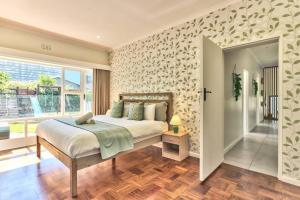 1 dormitorio con cama y ventana grande en Family Home, WiFi, Patio, Secure Parking, en Ciudad del Cabo