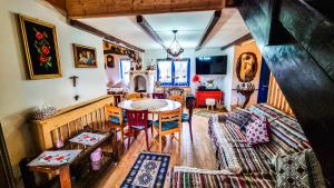 a living room with a table and a couch at Pensiunea „Căsuța cu maci” in Iaşi