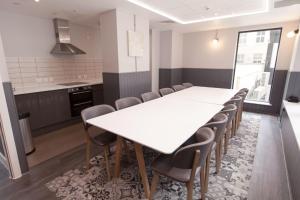 a kitchen and dining room with a white table and chairs at For Students Only Stylish Studio Apartments at Crown Place in Portsmouth in Portsmouth