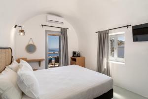 a bedroom with a bed and a view of the ocean at Evanthia Best View Thirassia Island Hotel in Therasia