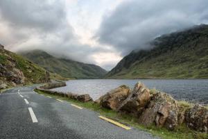 a road next to a body of water and mountains at Devlin farm life in Westport
