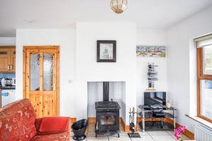 a living room with a fireplace and a red couch at Devlin farm life in Westport