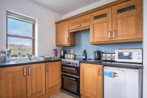 a kitchen with wooden cabinets and a stove top oven at Devlin farm life in Westport +22 photos