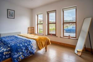 a bedroom with a bed and some windows at Devlin farm life in Westport