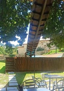 eine Terrasse mit Tischen, Stühlen und einem Zaun in der Unterkunft CASERIO RECTORAL DESTERIZ in Ourense