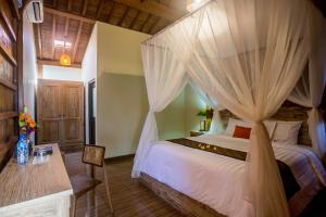 a bedroom with a bed with mosquito netting at Victory Munggu in Canggu