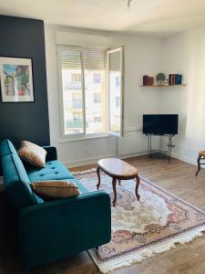 uma sala de estar com um sofá azul e uma mesa de centro em Charmant appartement em Épinal