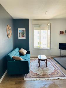 a living room with a blue couch and a table at Charmant appartement in Épinal