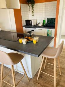 a kitchen with a table with two chairs and orange juice at Charmant appartement in Épinal