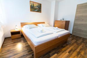 a bedroom with a large bed with white sheets at APARTMA JANJA in Bovec