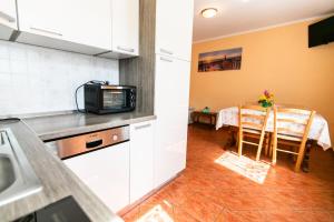 a kitchen and dining room with a table and a microwave at APARTMA JANJA in Bovec +12 photos
