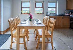 a wooden table and chairs in a kitchen at Devlin farm life in Westport
