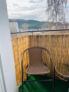 a rattan chair sitting on top of a balcony at Elli apartament in Gdynia