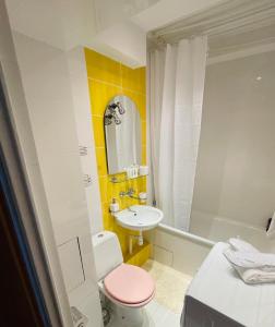 a bathroom with a pink toilet and a sink at Elli apartament in Gdynia