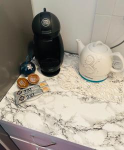 a counter top with a coffee maker and a tea kettle at Elli apartament in Gdynia