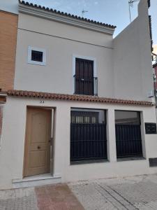 a white building with a door and two windows at CASA INDEPENDIENTE EN NERVION JUNTO A PARADA DEL METRO in Seville