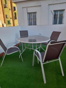 a table and chairs on a balcony with green grass at CASA INDEPENDIENTE EN NERVION JUNTO A PARADA DEL METRO in Seville