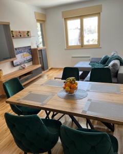 ein Wohnzimmer mit einem Holztisch und grünen Stühlen in der Unterkunft MM Sofy in Palisat