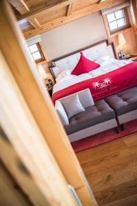 ein Schlafzimmer mit einem Bett und einem Sofa in einem Zimmer in der Unterkunft Riffelalp Resort 2222m in Zermatt