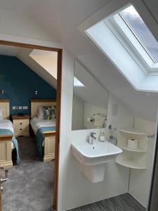 a bathroom with a sink and a bedroom with a bed at Karrawa Guest House in Kirkwall