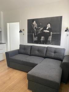 ein Wohnzimmer mit einem Sofa und zwei Personen auf Stühlen in der Unterkunft Appartement No 5 in Weimar